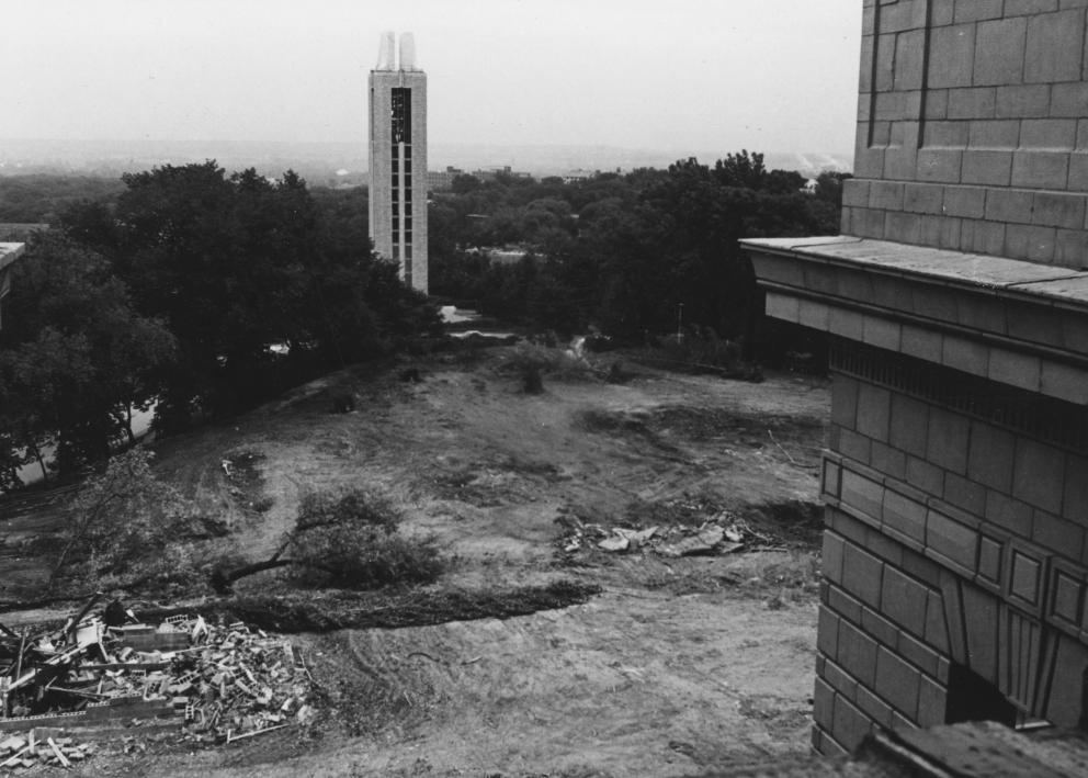 Black-and-white photograph of a large empty area behind Strong Hall and the Campanile. A small pile of rubble sits in the corner on the left.