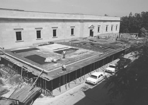 Black-and-white photograph of the terrace being built in layers and held up by temporary posts. Behind, the library building looks complete.